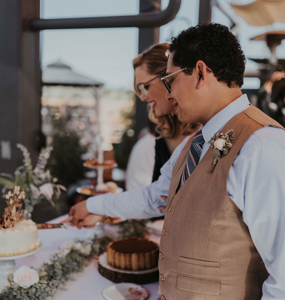 lauren_cake_backyard_paso_wedding_reception bride and groom cutting cake during a wedding reception at the backyard on thirteenth in downtown paso robles
